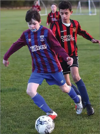  ??  ?? East Meath United’s Eoin McEvoytrie­s to shake off Paulo Ceka of Laytown United during Saturday’s Under-13 match.