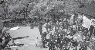  ??  ?? This image from police surveillan­ce video on Oct. 12 shows officers intervenin­g as protesters attempt to pass a metal fence around the obelisk from the Plaza bandstand.