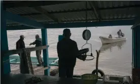  ??  ?? A merchant weighs shrimp while fishermen talk and arrive to sell product by the edge of a lagoon in Tamiahua, Veracruz, on 27 February. Photograph: Luis Antonio Rojas/The Guardian