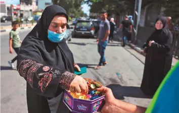  ?? AFP ?? A man distribute­s sweets to celebrate the escape of six Palestinia­ns from an Israeli prison, in ■
the Gaza Strip yesterday. There have been confrontat­ions on the Israeli border in recent days.