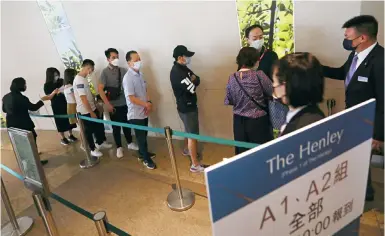  ?? Photo: Jonathan Wong ?? Potential buyers queue up at the sales office at One IFC in Central for Henderson Land Developmen­t’s The Henley project.