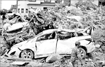  ??  ?? Rescue workers conduct search and rescue operations at a landslide site caused by heavy rain in Kumano Town, Hiroshima Prefecture, Japan – Reuters file photo