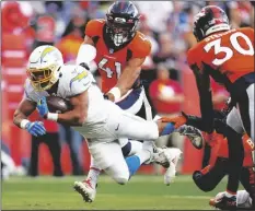  ?? AP PHOTO/JACK DEMPSEY ?? Los Angeles Chargers running back Austin Ekeler (30) dives into the end zone for a touchdown as Denver Broncos inside linebacker Kenny Young (41) defends during the first half of an NFL football game on Sunday in Denver.