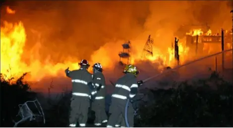  ?? AP Photo ?? Unionville firefighte­rs fight flames billowing from a Kingdom Road home late Sunday night near Rover, Tenn. Four people died in the fire, authoritie­s said.