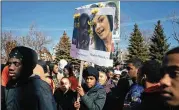  ?? ALYSSA SCHUKAR / NEW YORK TIMES ?? Zechariah Stepney carries a sign honoring the 17 who died in the Feb. 14 Florida school shooting as he and other Perspectiv­es High School of Technology students walked out Wednesday in Chicago.