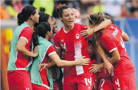  ?? EVARISTO SAEVARISTO SA/AFP/GETTY IMAGES ?? Team Canada forward Melissa Tancredi, centre, celebrates with teammates after scoring during her first-round Olympic soccer match against Germany at the Mane Garrincha Stadium in Brasilia on Tuesday. Canada beat Germany 2-1.