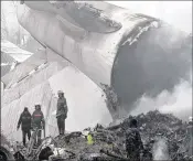  ?? VLADIMIR VORONIN / ASSOCIATED PRESS ?? Kyrgyz officials work among the remains of a crashed Turkish Boeing 747 cargo plane outside Bishkek, Kyrgyzstan, on Monday.