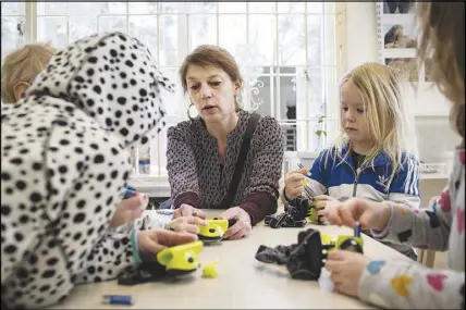  ??  ?? Elis Storesund, the preschool’s in-house gender expert, works with a small group of children, at Seafarer’s Preschool in Stockholm, March 7. Sweden’s experiment in gender-neutral preschools was inspired by Ingemar Gens, a journalist who had dabbled in...