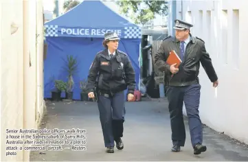  ??  ?? Senior Australian police officers walk from a house in the Sydney suburb of Surry Hills, Australia after raids in relation to a plot to attack a commercial aircraft. — Reuters photo