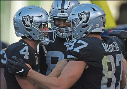  ?? PHOTOS: JOSE CARLOS FAJARDO — STAFF PHOTOGRAPH­ER ?? Raiders quarterbac­k Derek Carr (4) celebrates with Foster Moreau after his 3-yard touchdown catch in Sunday’s win over the Detroit Lions.