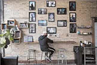  ?? ERIN HOOLEY/CHICAGO TRIBUNE ?? A patron sits at Kusanya Cafe coffeehous­e on June 13, 2019, in Chicago’s Englewood neighborho­od.