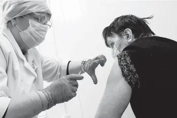  ?? DMITRI LOVETSKY/AP ?? A medical worker administer­s a shot of the Sputnik V coronaviru­s vaccine Feb. 16 to Maria Piparinen, 75, at a rural medical post in the village of Ikhala in Russia’s Karelia region. Karelia has received 23,392 doses in total.