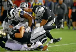  ??  ?? Derek Carr es derribado por el tackle de Rams, Michael Brockers, en la primera mitad.