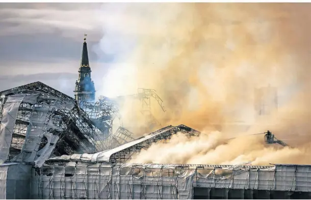  ?? FOTOS (2): EMIL HELMS/RITZAU SCANPIX FOTO/AP ?? Feuerwehrl­eute bei den Löscharbei­ten, während Rauch aus der alten Börse aufsteigt. nd