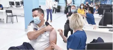  ?? Associated Press ?? ↑
Rural Fire Service member receives a Pfizer vaccine at the vaccinatio­n centre in Sydney on Monday.