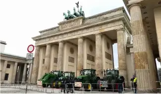  ?? ?? Des agriculteu­rs marchent entre des tracteurs alors qu'ils arrivent pour la manifestat­ion à Berlin, le lundi 15 janvier 2024.