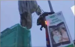  ?? YOUTUBE ?? A soldier with the 911 paratroope­r brigade clutches a lamppost in Phnom Penh after missing his landing area.