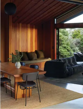 ??  ?? RIGHT Taking a holistic approach to the project, architect Belinda also specified all aspects of the interior, from the material and colour palettes through to the furniture, which includes a tōtara dining table she designed herself and teamed with Fifties chairs by Calligaris from Dawson & Co. Against the backdrop of cedar timber, her colour palette hints at the blues of the ocean, plus the greens of the pōhutukawa and other plants outside.