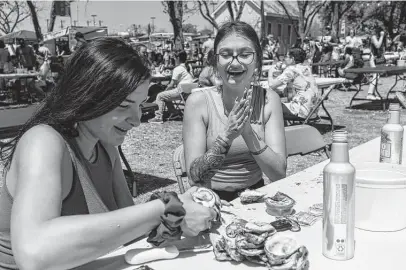  ?? Photos by Josie Norris / Staff photograph­er ?? Diana Kovpak cheers as Isabel Carrazana, both of San Antonio, shucks a tricky oyster Saturday during the 2022 Fiesta Oyster Bake held at St Mary’s University. The event returned after two years of being canceled due to the pandemic.
