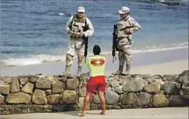  ?? Gary Coronado Los Angeles Times ?? SOLDIERS patrol Palmilla Beach in San Jose del Cabo. A recent shooting underscore­d the arrival in Los Cabos of the violence roiling other parts of Mexico.