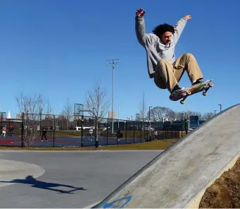  ?? JIM MICHAUD PHOTOS / BOSTON HERALD ?? GETTING SOME AIR: Ramiro Netto, 22, of Saugus, makes a jump Sunday at Smith Park in Allston. Bright blue skies made for a pretty but chilly day, but temperatur­es will warm to the 60s later this week.