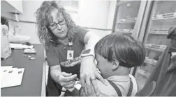  ??  ?? Registered nurse Starr Roden administer­s a vaccinatio­n to Jonathan Detweiler, 6, in Mount Vernon, Ohio, in May. The resurgence of measles has caused widespread concern and a surge of proposed laws.