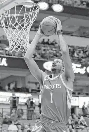  ?? Tony Gutierrez / Associated Press ?? Rockets forward Trevor Ariza gets up close and personal with the rim on a first-half dunk for two of his 23 points Wednesday against the Mavericks.