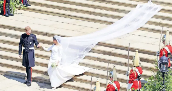  ??  ?? ► El príncipe Harry y Meghan Markle dejan la Capilla de San Jorge, en el Castillo de Windsor, después de su boda.