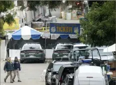  ?? Noah Berger/ Associated Press ?? FBI personnel pass a ticket booth at the Gilroy Garlic Festival Monday in California, the morning after a gunman killed at least three people, including a 6- year- old boy, and wounded about 15 others.