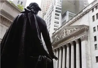  ??  ?? NEW YORK: The statue of George Washington on the steps of Federal Hall faces the facade of the New York Stock Exchange. —AP