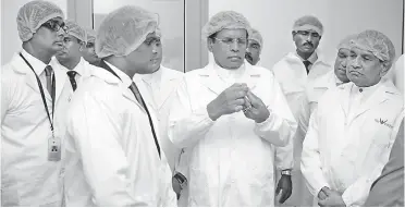  ??  ?? The President inspecting a finish product (dry powder injectable vial) during his tour of the factory