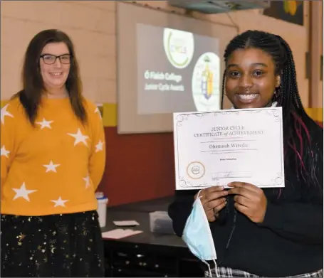  ??  ?? Ohemaah Wiredu receives her certificat­e for excellence in Home Economics from teacher Rachel Doyle at the Ó Fiaich College Junior Cycle Awards Ceremony