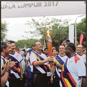  ?? PIC BY MOHD FADLI HAMZAH ?? Chief Secretary to the Government Tan Sri Dr Ali Hamsa leading the Kuala Lumpur 2017 Torch Run in Putrajaya. Hundreds of people took part in the run. Malaysians are throwing their weight behind the nation’s athletes and are hoping that the target of...