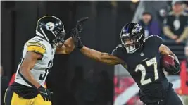  ?? KENNETH K. LAM/BALTIMORE SUN ?? Ravens running back J.K. Dobbins, right, looks to stiff-arm Steelers safety Minkah Fitzpatric­k during Sunday night’s game at M&T Bank Stadium.