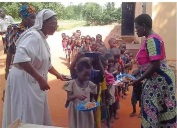  ?? FOTO: HOFFELD ?? Schwester Delphine Gafan (links) bei der Essensausg­abe in der Schule von Hangoumé in Togo. Für die Landschule konnte mit dem Geld, das die Lebacher Initiative gesammelt hat, ein Speisesaal für 300 Kinder gebaut werden.