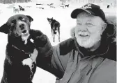  ?? AL GRILLO/AP 2005 ?? Children’s book author Gary Paulsen, who deeply identified with the outdoors, sits with his favorite Alaskan husky, Flax, at his Willow, Alaska, home.