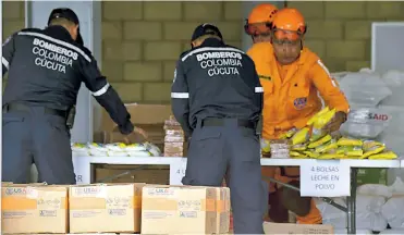  ?? AFP ?? Bomberos y defensa civil organizan alimentos y medicament­os enviados desde Estados Unidos.