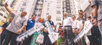  ?? ASHRAF SHAMSUL/ THESUN ?? Najib with some of the recipients of the PPA1M housing units during the handover ceremony in Putrajaya yesterday.