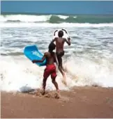  ??  ?? Children enjoy body boarding during the annual internatio­nal surf day competitio­n on Kokrobite Beach.