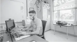  ?? JENNIFER LETT/SOUTH FLORIDA SUN SENTINEL ?? Michael Lichtenste­in, a U.S. government, politics and financial literacy professor at Pompano Beach High School, prepares for distance learning amid the pandemic at the high school on Friday.