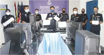  ?? ?? A police photo shows Ahsmon (fourth left) and his team members with the items seized during the raid.