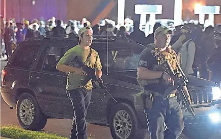  ?? ADAM ROGAN/THE JOURNAL TIMES VIA AP ?? Kyle Rittenhous­e, left, and other armed men claimed to be protecting property owners from arson and theft during protests Aug. 25, 2020, in Kenosha, Wis.