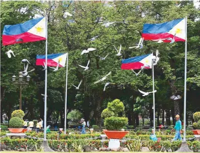  ?? EDD GUMBAN ?? Pigeons fly past Philippine flags set up at Rizal Park yesterday.