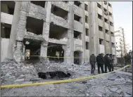  ?? (AP/Omar Sanadiki) ?? Syrian security officers inspect damage in a residentia­l neighborho­od Sunday after an early morning Israeli airstrike in Damascus, Syria. Video at arkansason­line.com/220damascu­s/.