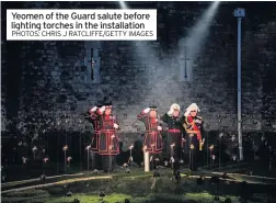  ?? PHOTOS: CHRIS J RATCLIFFE/GETTY IMAGES ?? Yeomen of the Guard salute before lighting torches in the installati­on