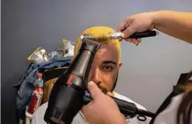  ?? Alejandro Granadillo/Associated Press ?? A fan of the Puerto Rico baseball team gets his hair dried after it was bleached as part of a mass hair dying event in an attempt to break the Guinness World Record for the most hair dyed in eight hours in Guaynabo, Puerto Rico, on Friday.