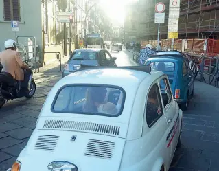  ??  ?? Le auto, alla porta Telepass in piazza Cavallegge­ri, in attesa (vana) dell’apertura della «finestra» della Ztl, l’anno scorso. A destra, il parcheggio selvaggio è già ricomincia­to