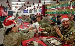  ?? — AP ?? Members of the US military eat Christmas dinner at the Resolute Support Headquarte­rs in Kabul on Monday.