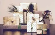  ??  ?? Gifts wrapped in gold, green and brown tones and topped with foliage will appeal to a nature-lover.