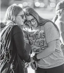  ?? Al Diaz / Associated Press ?? Emma Rothenberg, left, with her mother, Cheryl , embrace at a memorial marking the one-year anniversar­y of the school shooting. Many of the victims’ families made a joint public appearance Wednesday after meeting with Gov. Ron DeSantis.
